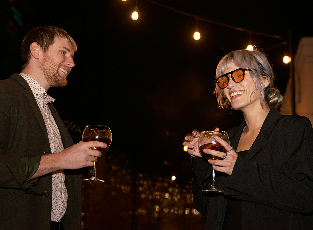 Guests enjoying drinks on a rooftop terrace with city views